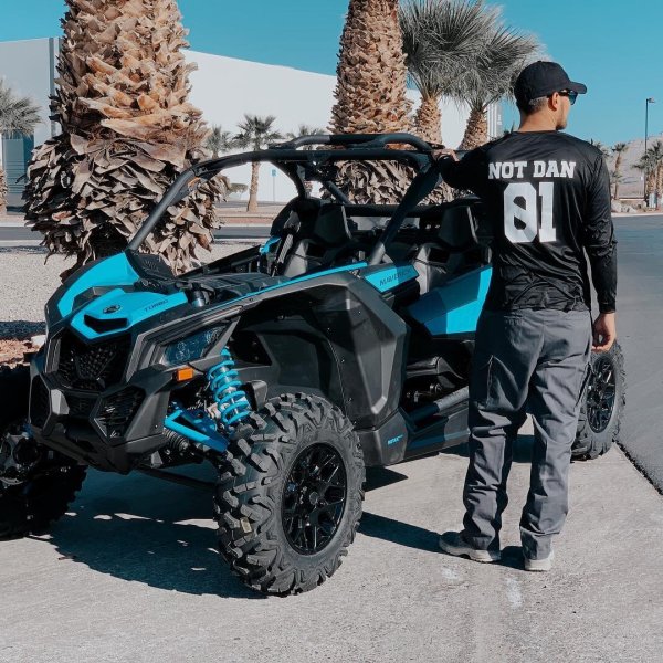 a man standing near a blue Can-Am