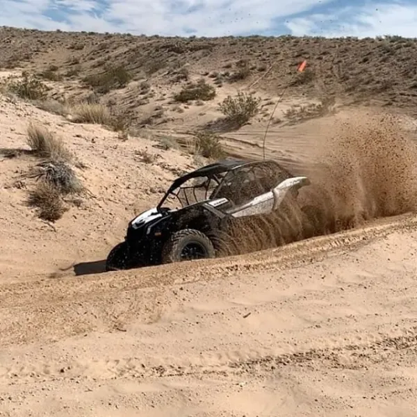 Can-Am Maverick X3s spinning sand up in the air