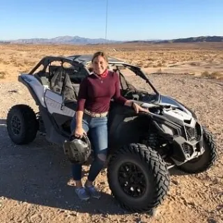 a woman standing near a Can-Am Maverick X3s