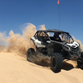 Can-Am Maverick X3s riding over a sand dune